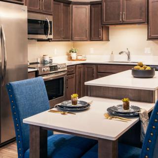 A modern kitchen with stainless steel appliances and a cozy dining area.