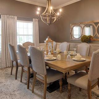 A beautifully decorated dining room with an elegant table setting and chandelier.