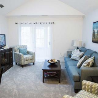A cozy living room with a blue sofa, an armchair, and a television.