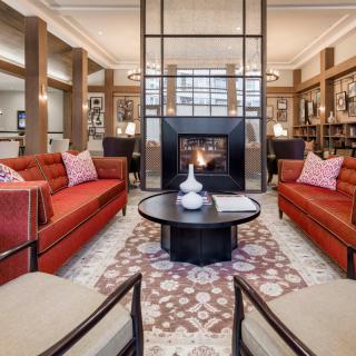 Elegant living room with red sofas and a central fireplace.