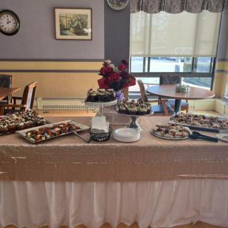 A buffet table set with a variety of desserts in an indoor dining area.