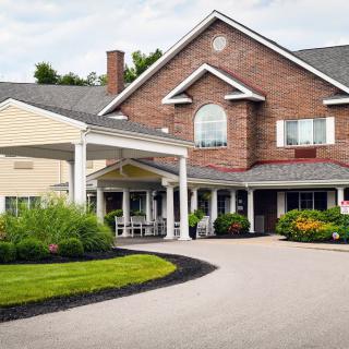 A well-maintained residential building with a covered entrance and landscaped surroundings.