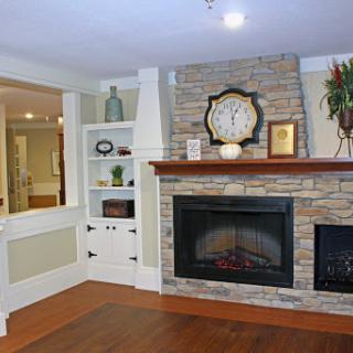 A cozy living room featuring a stylish stone fireplace and elegant decor.