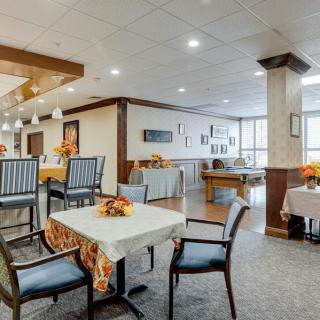 A modern and cozy dining area with neatly arranged tables and chairs, adorned with decorative centerpieces.