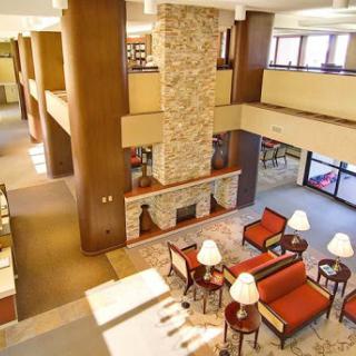 A spacious hotel lobby featuring comfortable seating, a stone fireplace, and an inviting atmosphere.