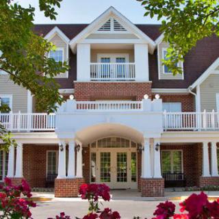 A beautiful residential building with a landscaped entrance and blooming flowers.