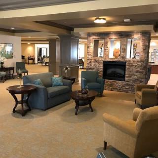 A cozy lobby area featuring comfortable seating around a stone fireplace.