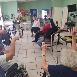 Elderly participants engage in a group exercise session, promoting physical activity and community interaction.