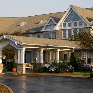 A large residential building with a welcoming entrance and landscaped front yard.