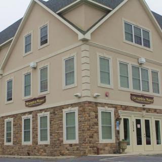 A charming three-story building with a mix of stone and cream-colored exterior.