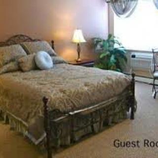 Cozy guest room with a neatly made bed and warm lighting.