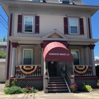 A two-story house with a red awning and decorative banners on the front porch.