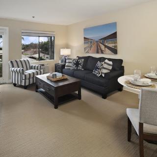 A cozy living room with a sofa, coffee table, and large window.