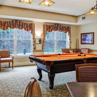 A cozy billiard room featuring a pool table and elegant furnishings.