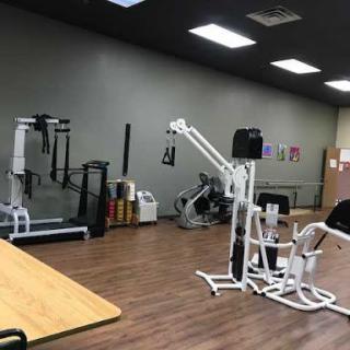 A well-equipped gym area featuring various exercise machines for strength training.