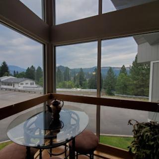 A cozy dining area with a stunning view of the mountains and lush greenery outside.