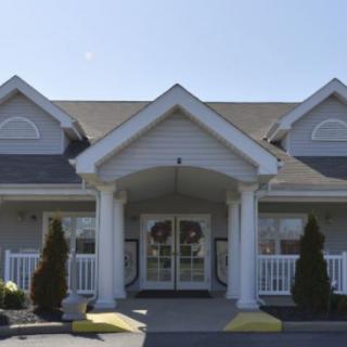 A front view of a house with white columns and a gable roof.