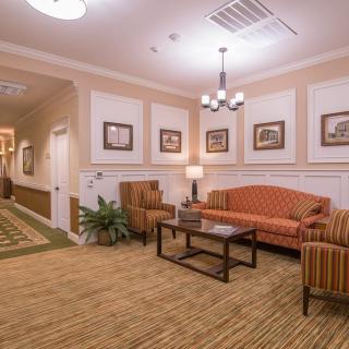 A cozy lobby area with a sofa, armchairs, and decorative artwork.