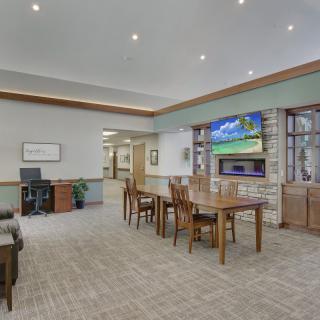A modern common area featuring comfortable seating, tables, and a TV.