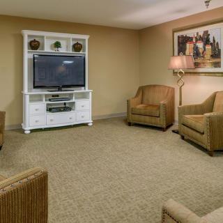 A cozy living room with comfortable armchairs and a television on an entertainment center.