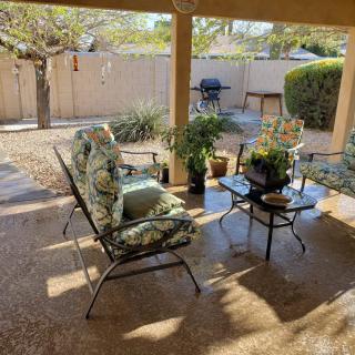 A sunny patio with comfortable seating and plants creating a relaxing outdoor space.