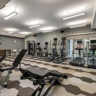 A modern gym with various exercise equipment including treadmills and weight benches.