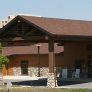 The image shows the entrance of a building with stone pillars and a sloped roof.