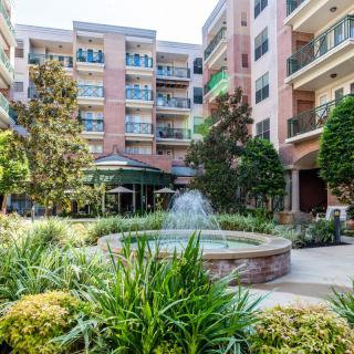 A beautiful courtyard with a fountain surrounded by residential buildings and lush greenery.