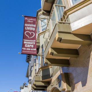 A city building with a banner advertising a senior living community and cafe.