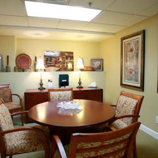A cozy conference room featuring a round table and comfortable chairs, ideal for meetings.