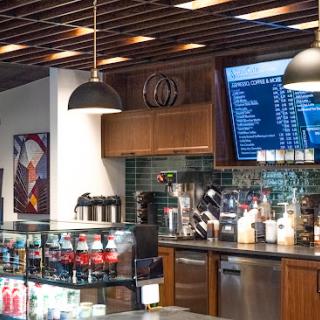 A modern coffee shop interior showcasing a variety of beverages and a stylish menu board.