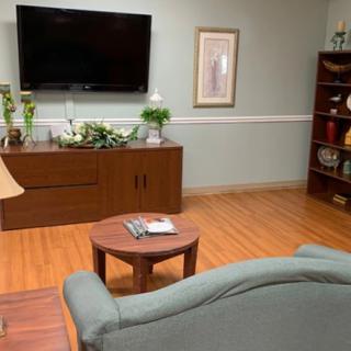 A cozy living room with a television, sofa, and wooden furniture.