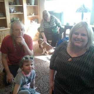 A joyful family gathering with smiles and pets in a cozy living room.