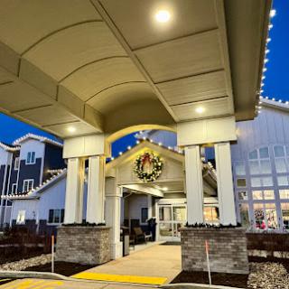 A beautifully lit entrance to a building adorned with festive decorations at dusk.