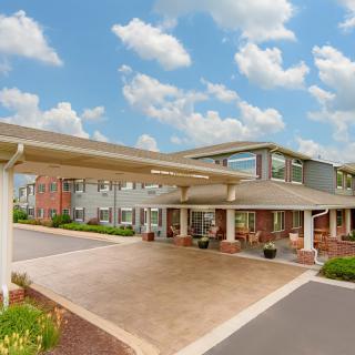 A modern building with a covered entrance and landscaped surroundings.