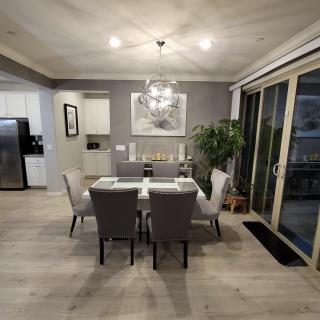 A modern dining room with a stylish table and chairs, featuring elegant lighting and decor.