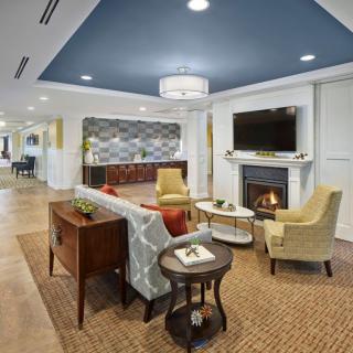 A cozy living room with modern furnishings, featuring a fireplace, television, and comfortable seating.