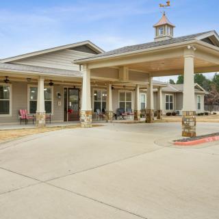 A residential building with a covered entrance and driveway.