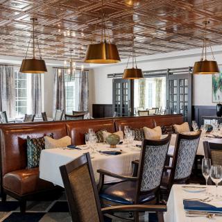 An upscale restaurant interior with elegant table settings and cozy seating arrangements.
