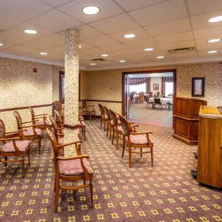 An empty meeting room with arranged chairs and a podium.