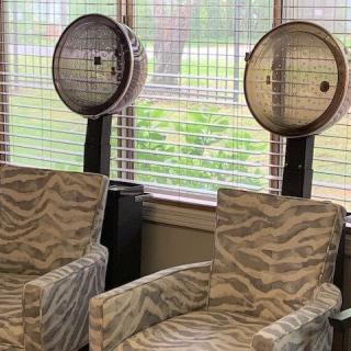 Vintage hair salon with classic hooded hair dryers and patterned chairs.