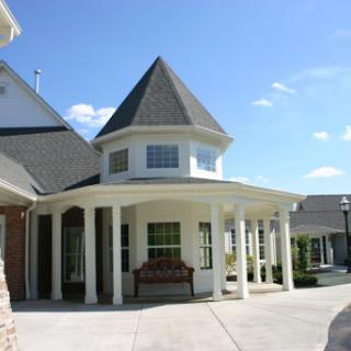 A charming residential building with a welcoming porch and turret.