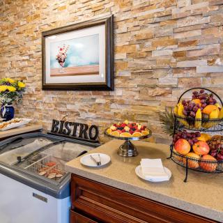 A cozy bistro counter with fruits, desserts, and ice cream.