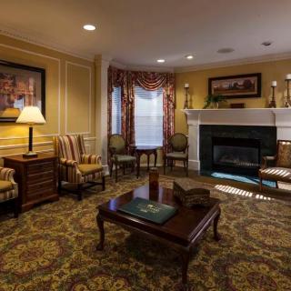 A cozy living room with traditional decor, featuring a fireplace and classic furniture.