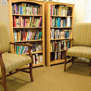 A cozy reading area with bookshelves and comfortable chairs.