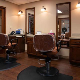 An interior view of a hair salon with styling chairs and mirrors.