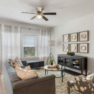 A modern living room featuring a comfortable sofa, glass coffee table, and decorative artwork on the walls.