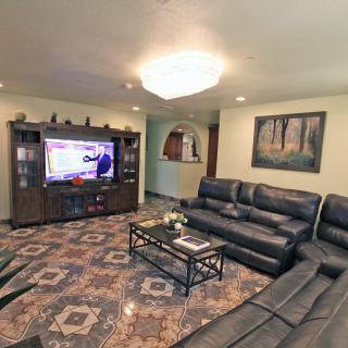 A modern living room with a large television, leather sofas, and a stylish coffee table.