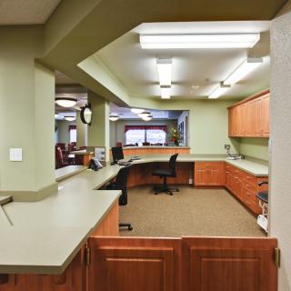 A modern office reception area with desks and chairs.