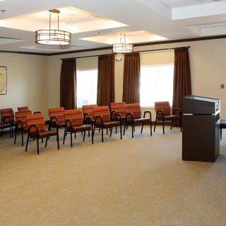 A small conference room with arranged chairs and a podium.